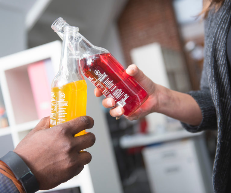 A team cheers with fruit drinks – Ten Adams